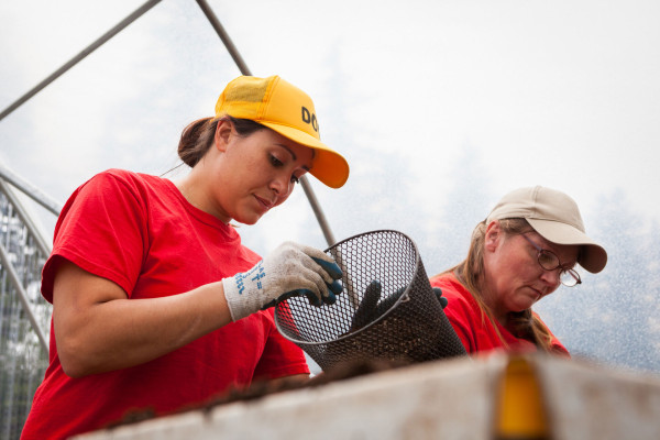 Two members of the SPP conservation nursery crew at Washington Corrections Center for Women work inside one of the hoop houses. Photo by Benj Drummond and Sara Joy Steele.
