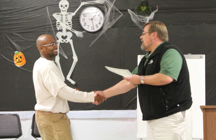 A Roots graduate receives his congratulations from Superintendent Cole. Photo by Joslyn Rose Trivett.