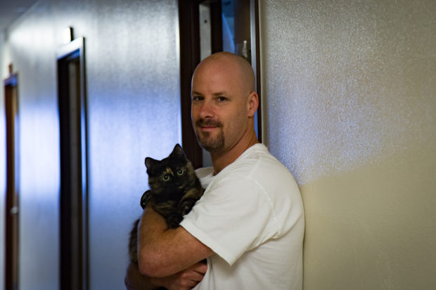 Another member of Larch's cat program poses with his cat. Photo by Ricky Osborne.