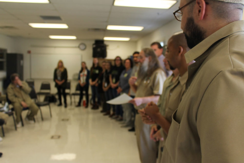 The Roots of Success program is an environmental course taught by incarcerated instructors. In this photo, VIPs line up to congratulate graduates of a Stafford Creek Corrections Center class. Photo by Bethany Shepler. 