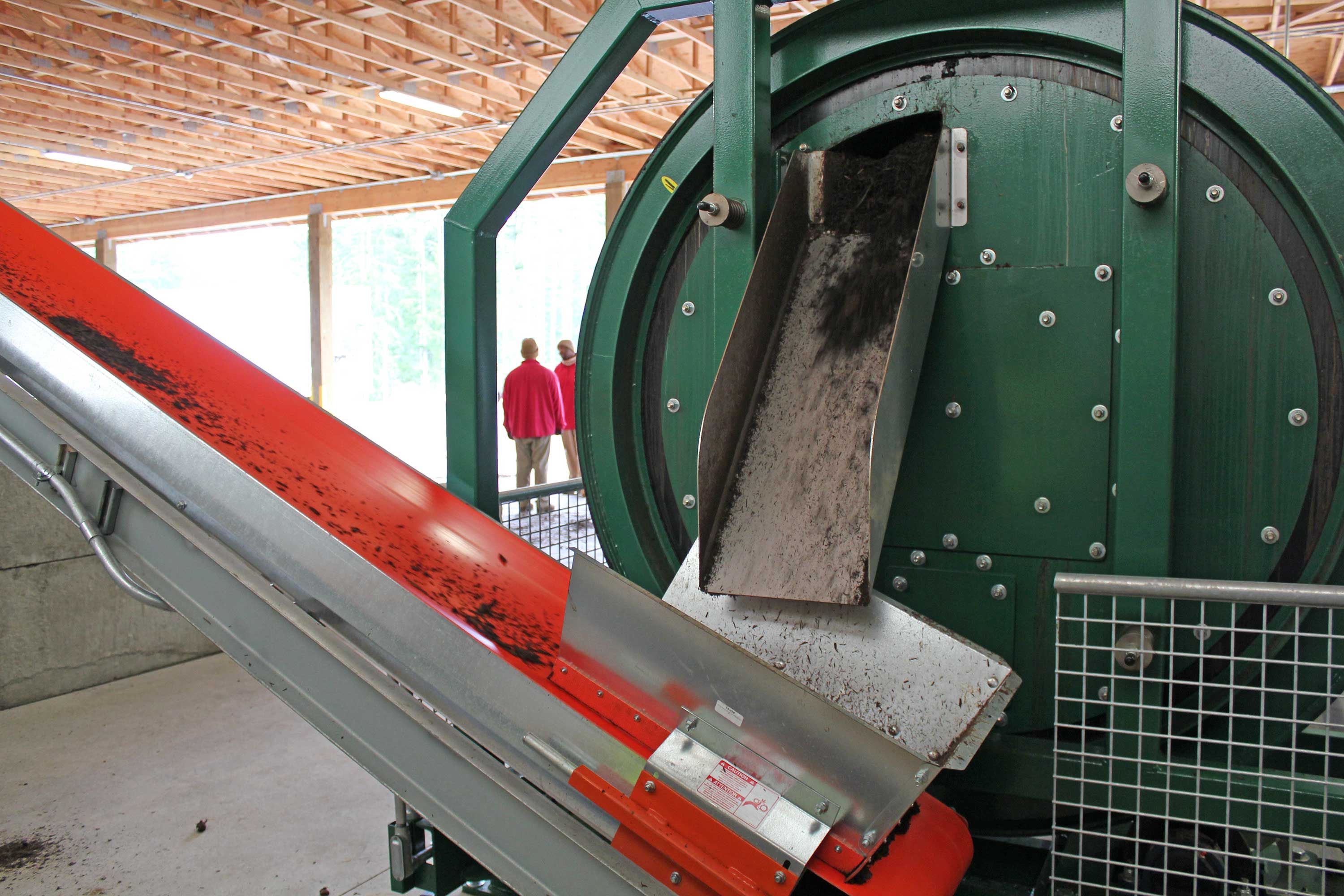 The new in-vessel composter at CCCC. This is the back end of the drum, and finished compost is falling onto the conveyor ramp that takes it to a holding pile. 