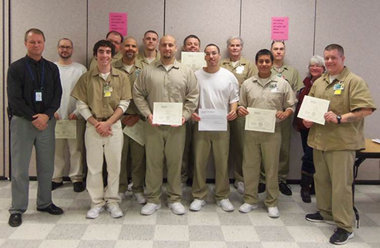 Roots graduates show their certificates alongside Superintendent Key and the staff sponsor for the program. Photo by DOC staff.