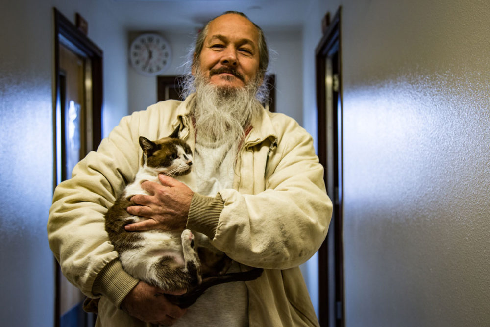Cat handler Leon Fannon enjoys the cat in his care at Larch Corrections Center. Photo by Ricky Osborne. 